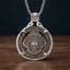 biker skull coin pendant necklace — shield badge with skull and wings hand-cut on coin face, E pluribus unum 1893 inscription, four-prong open frame, skull bail, antique silver tone, dark wood surface