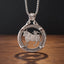 taurus zodiac coin pendant necklace — charging bull with winged cupid figure on back, floral rose border ring, four-prong open frame, ornate skull bail, antique silver tone, warm wood surface