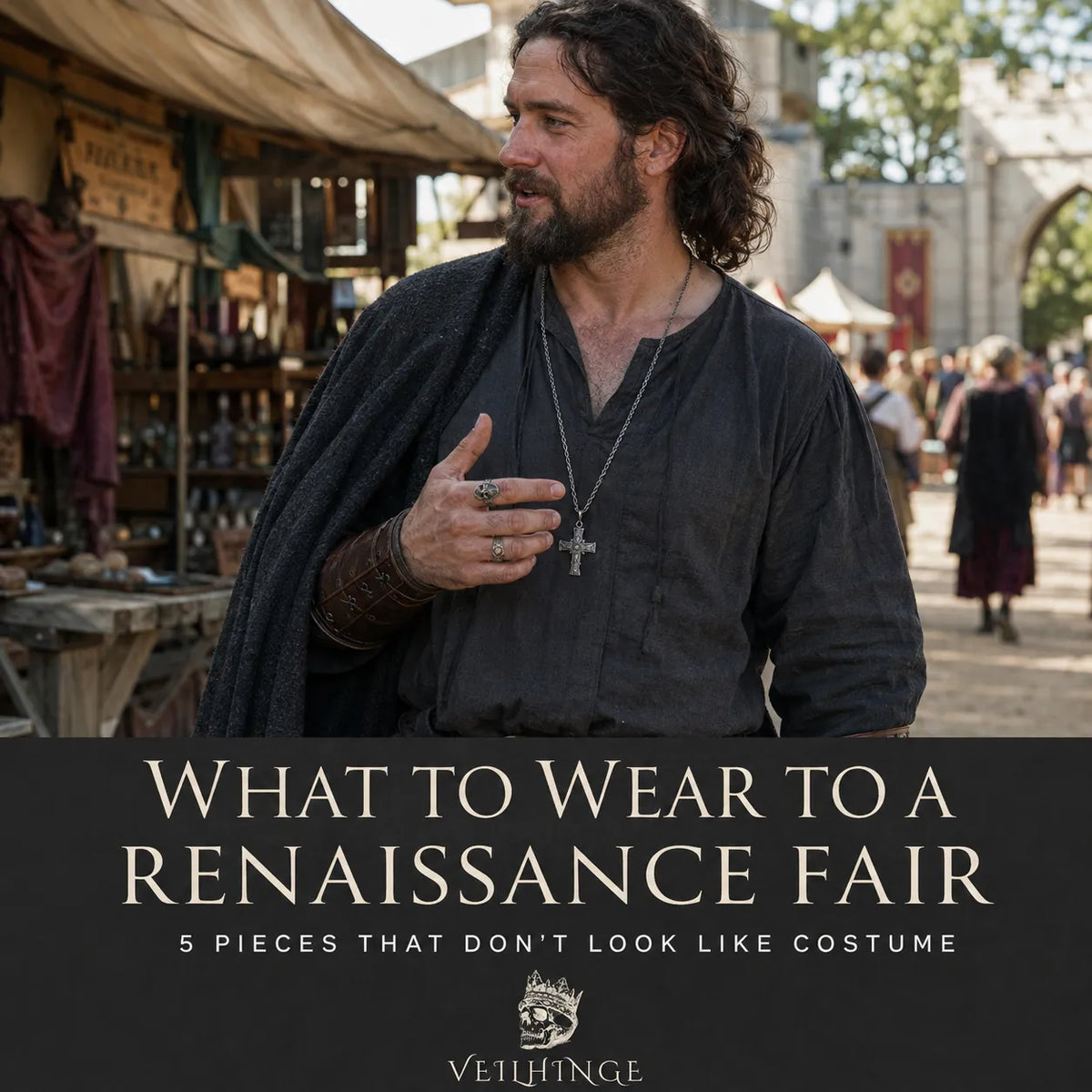 Man wearing oxidized rings and a silver cross pendant while talking at an outdoor Renaissance fair.