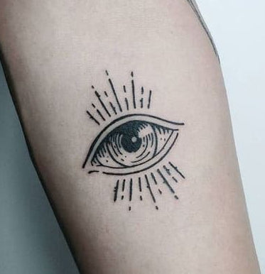 minimalist eye tattoo on forearm — radiating eye symbol, dark aesthetic tattoo, awareness and protection meaning