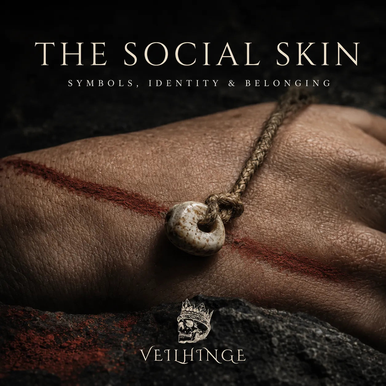 Ancient perforated shell bead resting on ochre-marked human skin, illustrating how body adornment expresses identity and belonging.