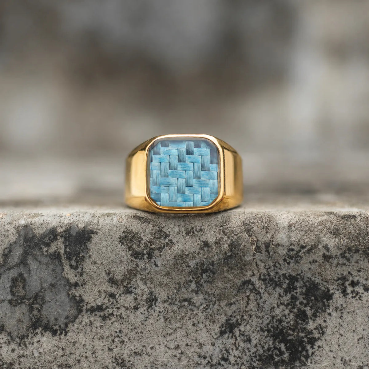 Front view of an 18K gold-plated signet ring with a light blue woven inlay Main image