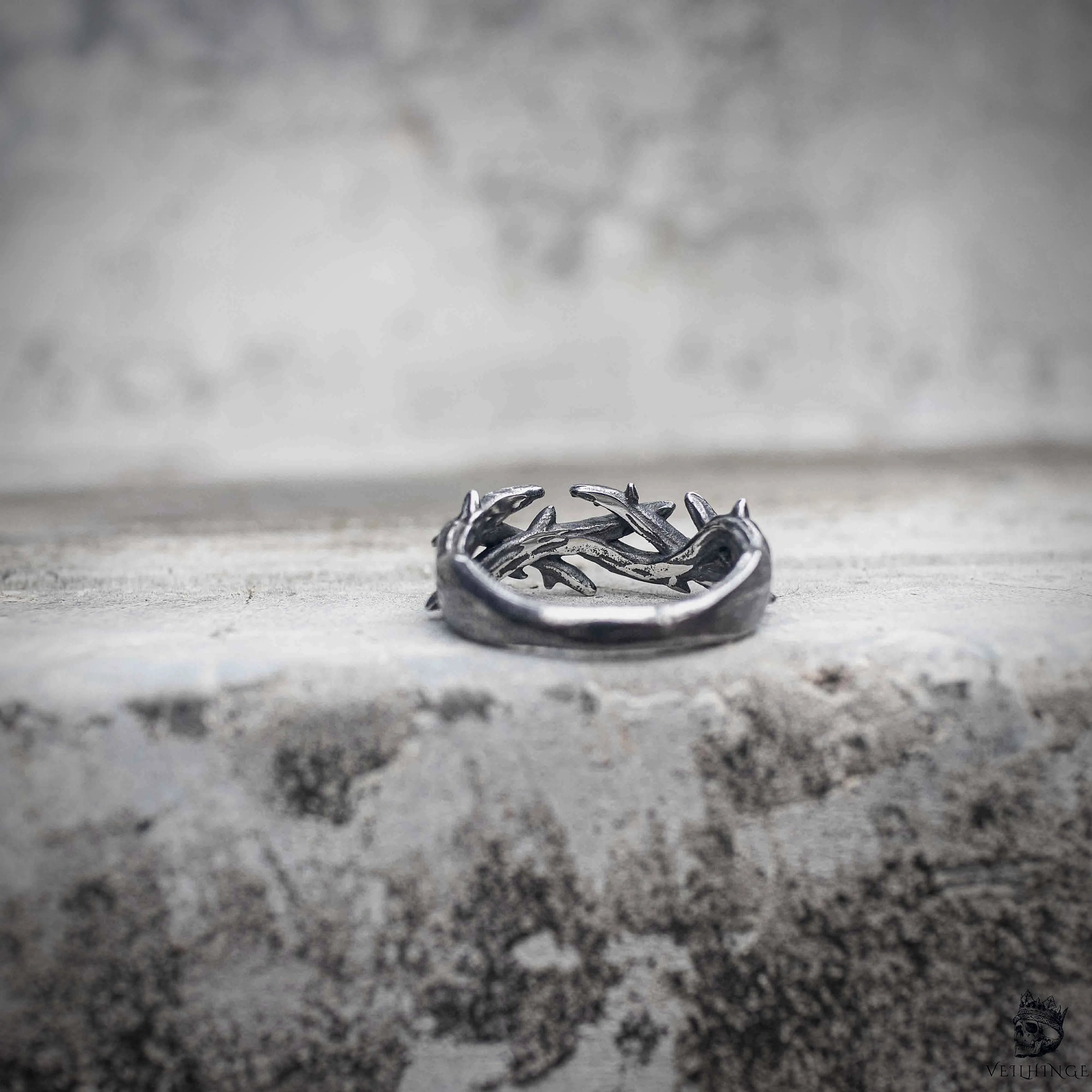Crown of thorns band ring flat lay showing thorn wreath structure in oxidized black stainless steel, gothic dark aesthetic stackable ring by Veilhinge