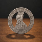 A silver-colored commemorative coin featuring a detailed profile of a skull wearing a crown, with the text 'E. PLURIBUS UNUM' and '1921' on a wooden surface against a dark background.