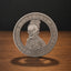 A silver-colored commemorative coin featuring a detailed profile of a skull wearing a crown, with the text 'E. PLURIBUS UNUM' and '1921' on a wooden surface against a dark background.