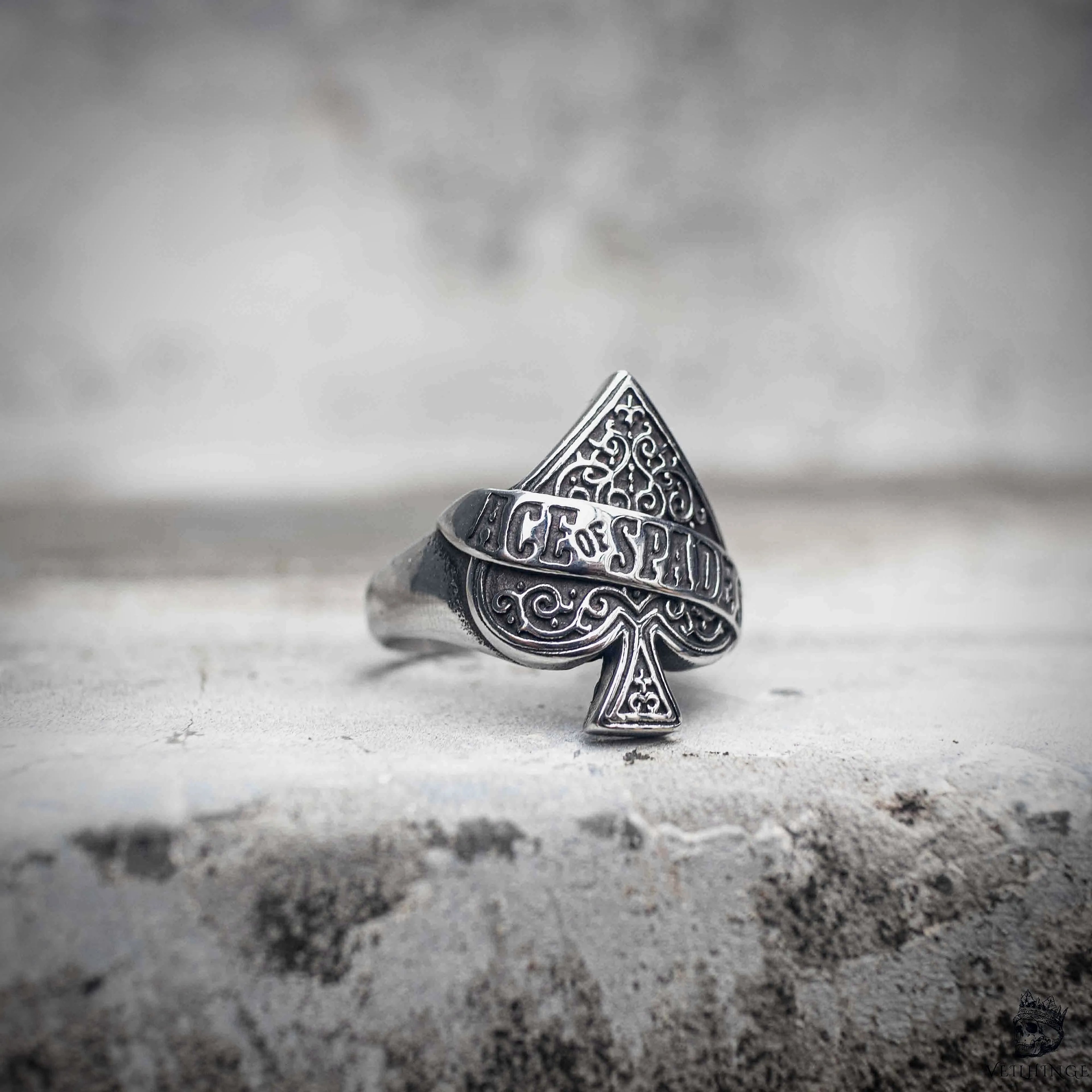 Ace of spades ring with baroque scroll engraving and ACE OF SPADES banner inscription, polished stainless steel dark aesthetic biker ring by Veilhinge, front view