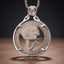 E.T. hobo coin pendant necklace — alien portrait hand-cut on 1921 coin face, E pluribus unum inscription, four-prong open frame, skull bail, antique silver tone, dark wood surface