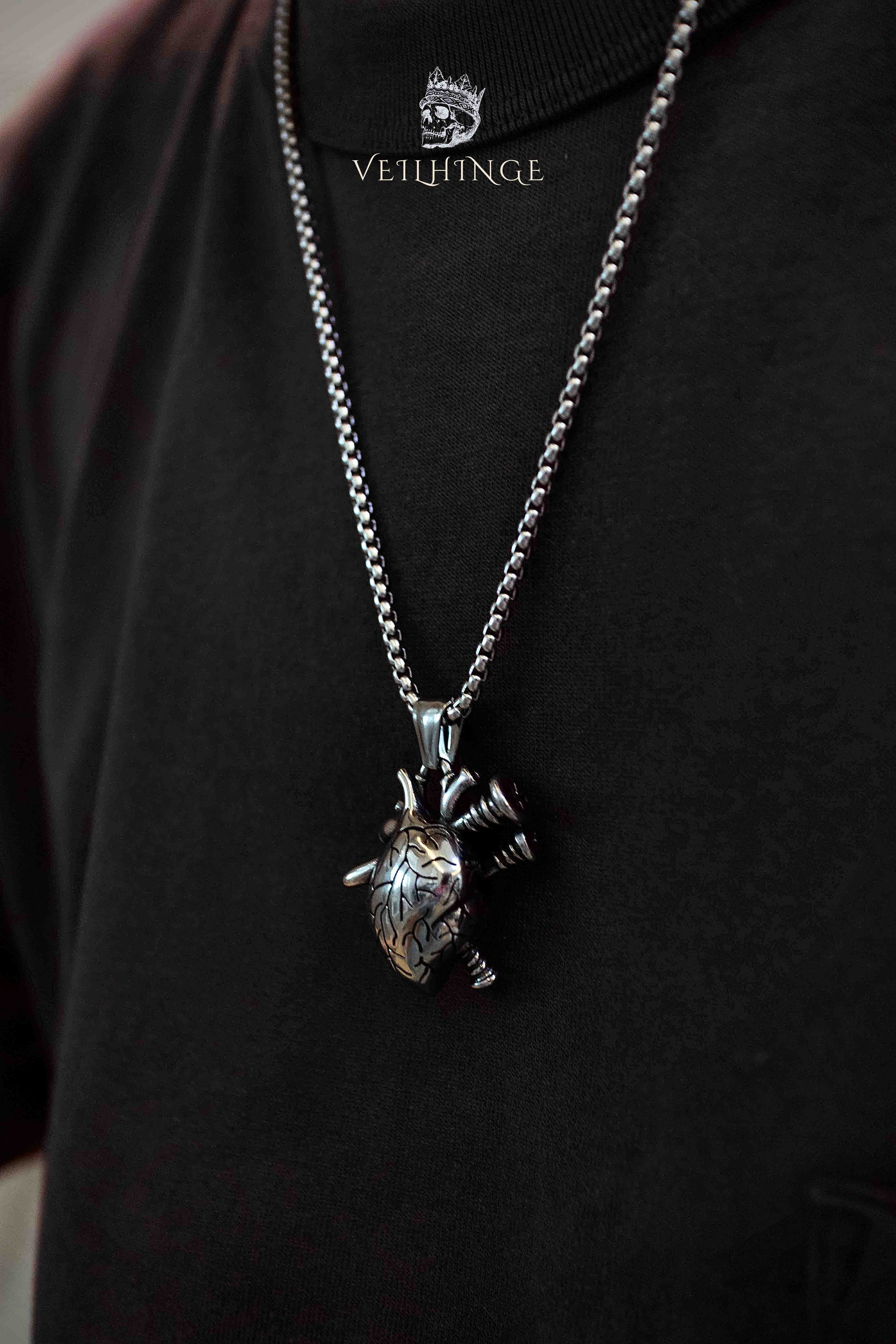 Anatomical heart pendant necklace with screw detail worn on model, three-dimensional heart with black screws, oxidized silver, dark aesthetic gothic jewelry