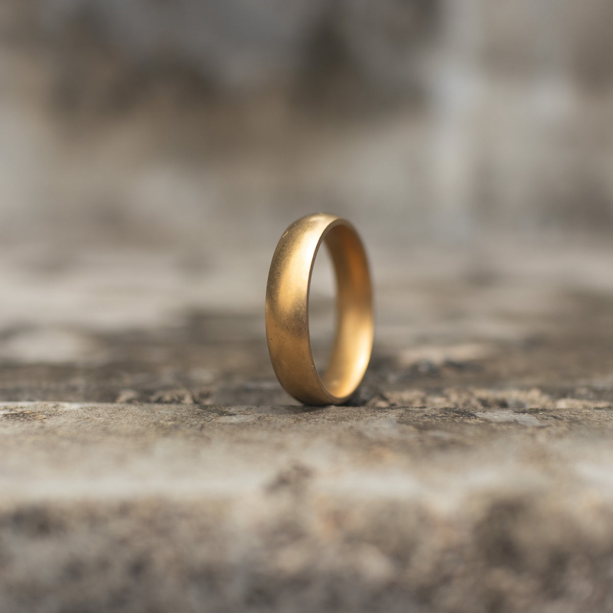 Antique gold-tone plain band ring standing upright in side view