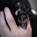 Articulated demon ring worn on a bent finger with the eye open, blackened claw structure against a dark lace background — gothic full finger ring