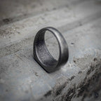 Minimalist signet ring side view showing rounded band profile and sandblasted oxidized black stainless steel finish, dark aesthetic ring by Veilhinge