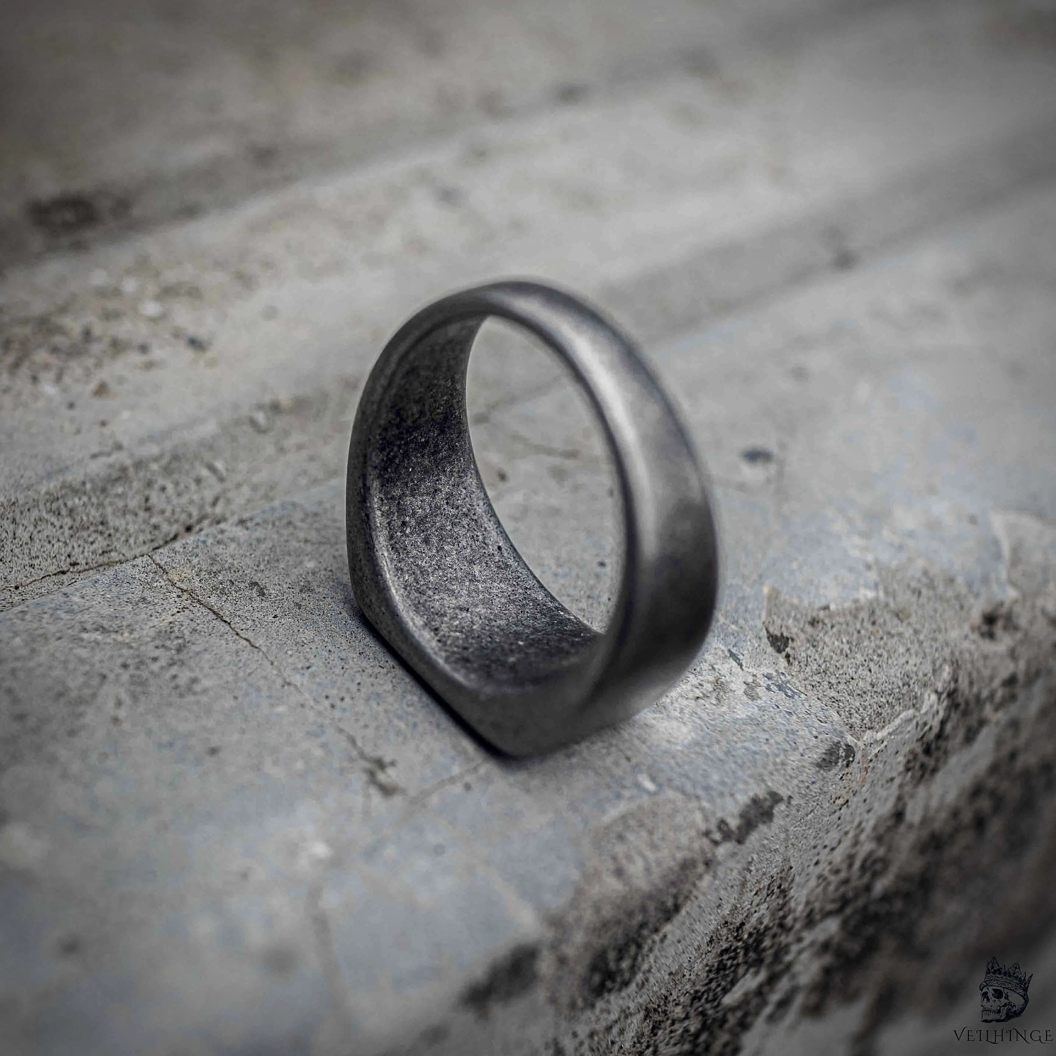 Minimalist signet ring side view showing rounded band profile and sandblasted oxidized black stainless steel finish, dark aesthetic ring by Veilhinge