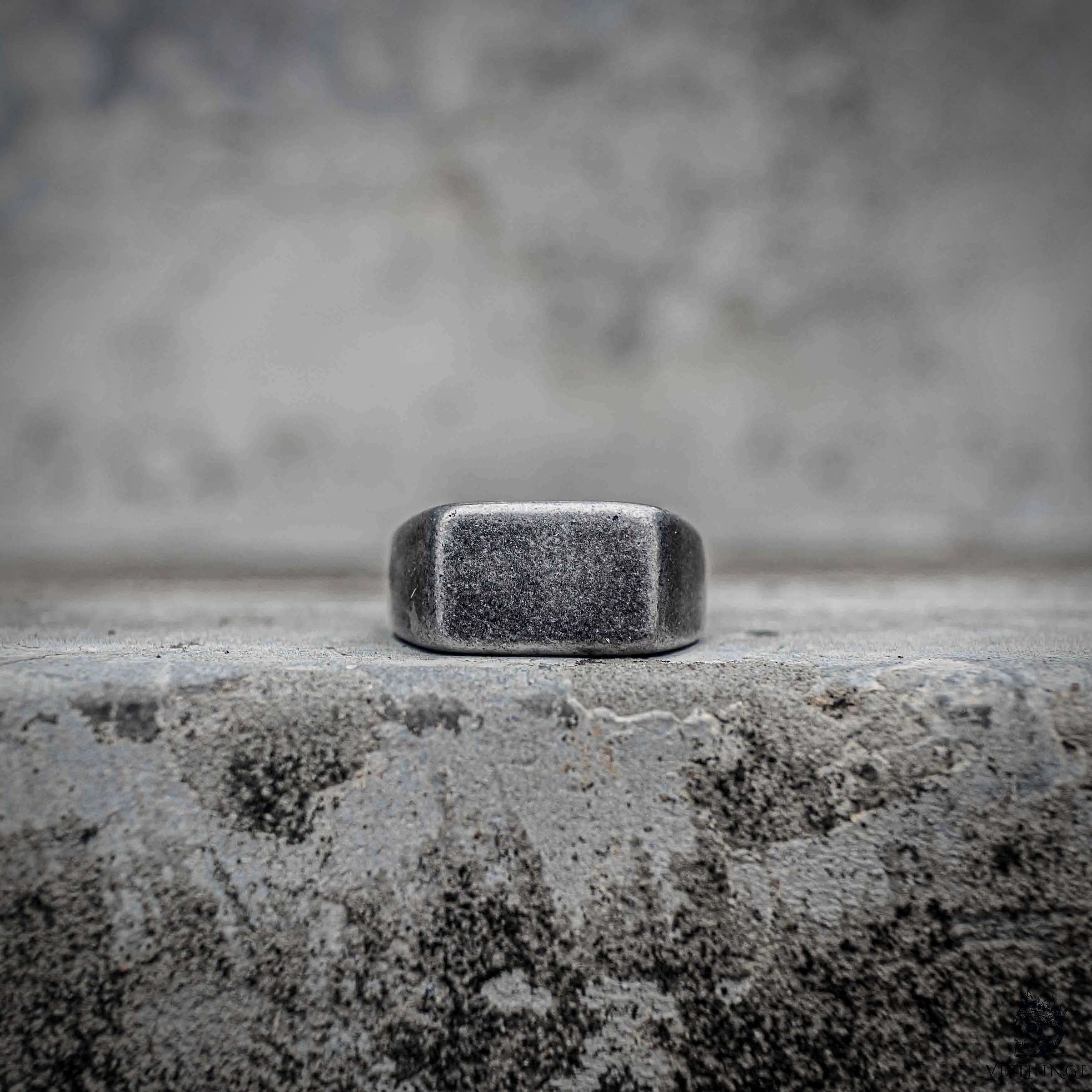 Blank signet ring with sandblasted matte rectangular face in oxidized black stainless steel, minimalist dark aesthetic ring by Veilhinge, front view
 Main image