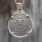 Coin pendant engraved with a bull skull below the Eye of Providence, flanked by spread wings and rose details, dated 1921, set in a four-prong bezel on a box chain