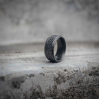 Celtic braid ring side view showing dense knot weave texture and polished stainless steel interior, oxidized black dark aesthetic band ring by Veilhinge