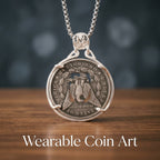 coin art pendant reverse side — Morgan dollar eagle motif with United States of America inscription in four-prong circular silver mount, skull bail
