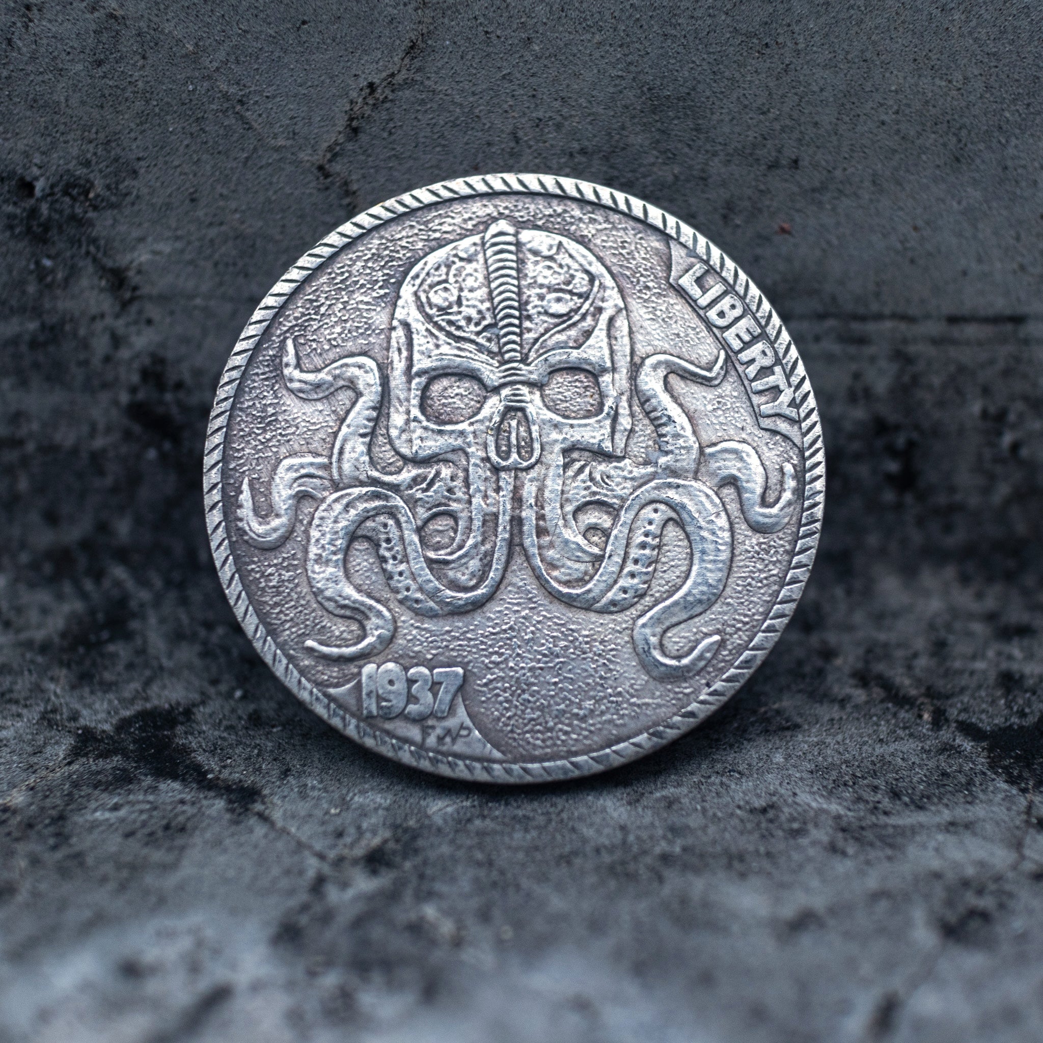 Coin pendant engraved with a skull merging into octopus tentacles spreading across the coin face, Liberty inscription, dated 1937, set in a four-prong bezel on a chain