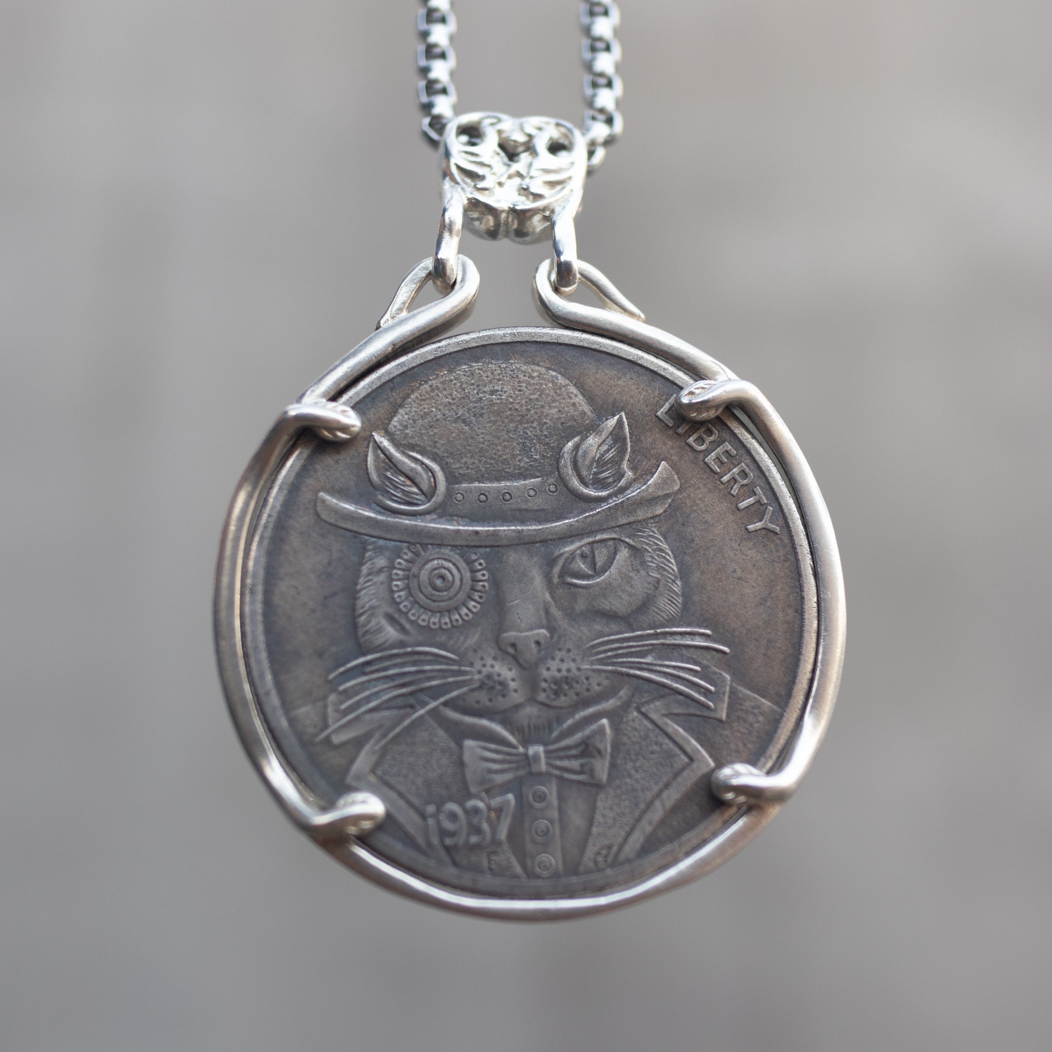 Coin pendant engraved with a dapper cat in a bowler hat and bow tie, Liberty inscription, dated 1937, set in a four-prong bezel on a decorative chain Main image