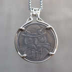 Coin pendant engraved with a dapper cat in a bowler hat and bow tie, Liberty inscription, dated 1937, set in a four-prong bezel on a decorative chain