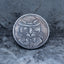 Close-up of a coin engraved with a dapper cat wearing a bowler hat and bow tie, concentric circle eyes, whiskers, Liberty inscription, dated 1937