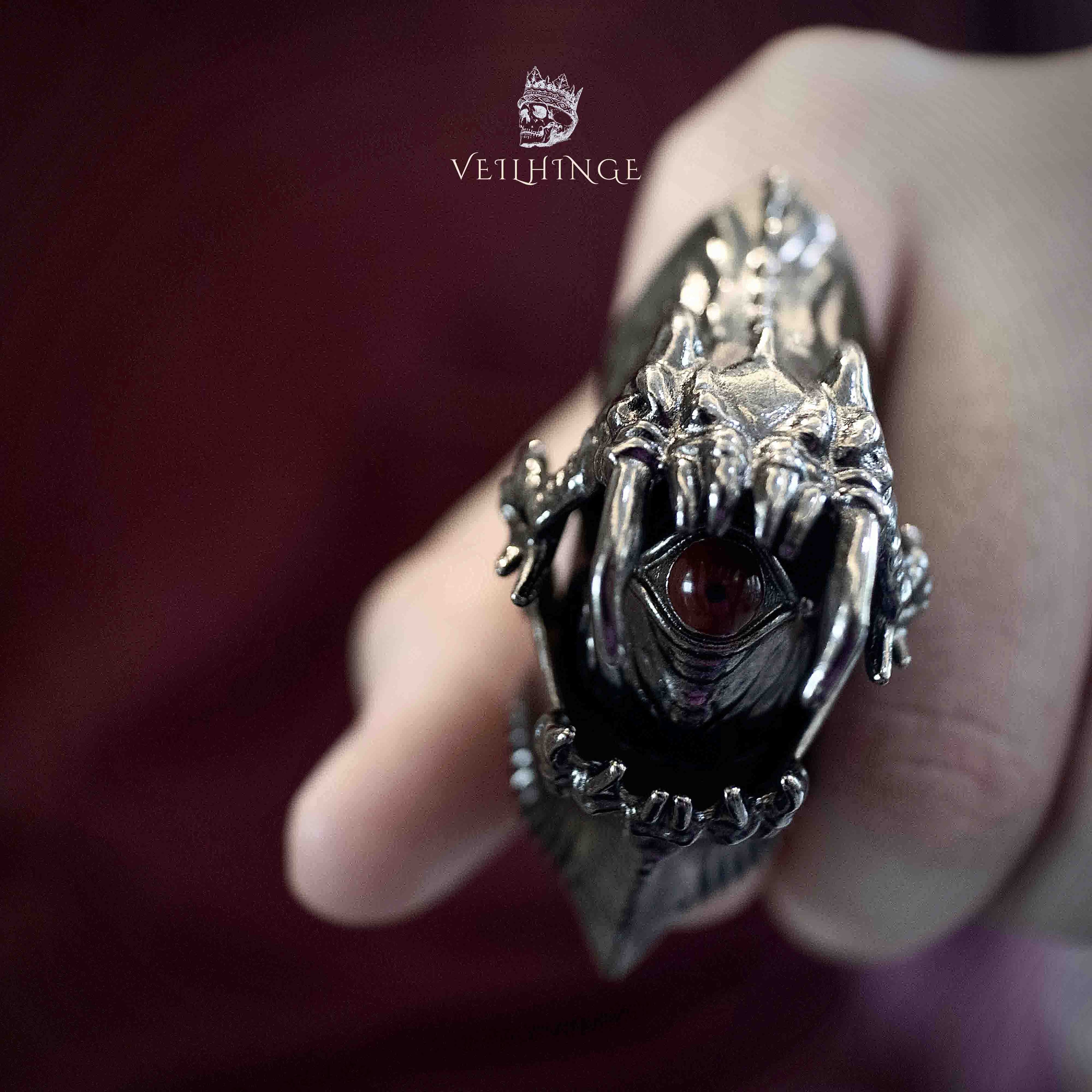 Demon eye armor ring with the eye fully open as the finger bends, dark claw frame revealing the eye at the center of the ring face