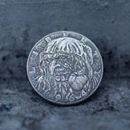 Close-up of a coin engraved with the Evil Queen witch in hooded cloak, poison apple visible at lower right, dated 1964