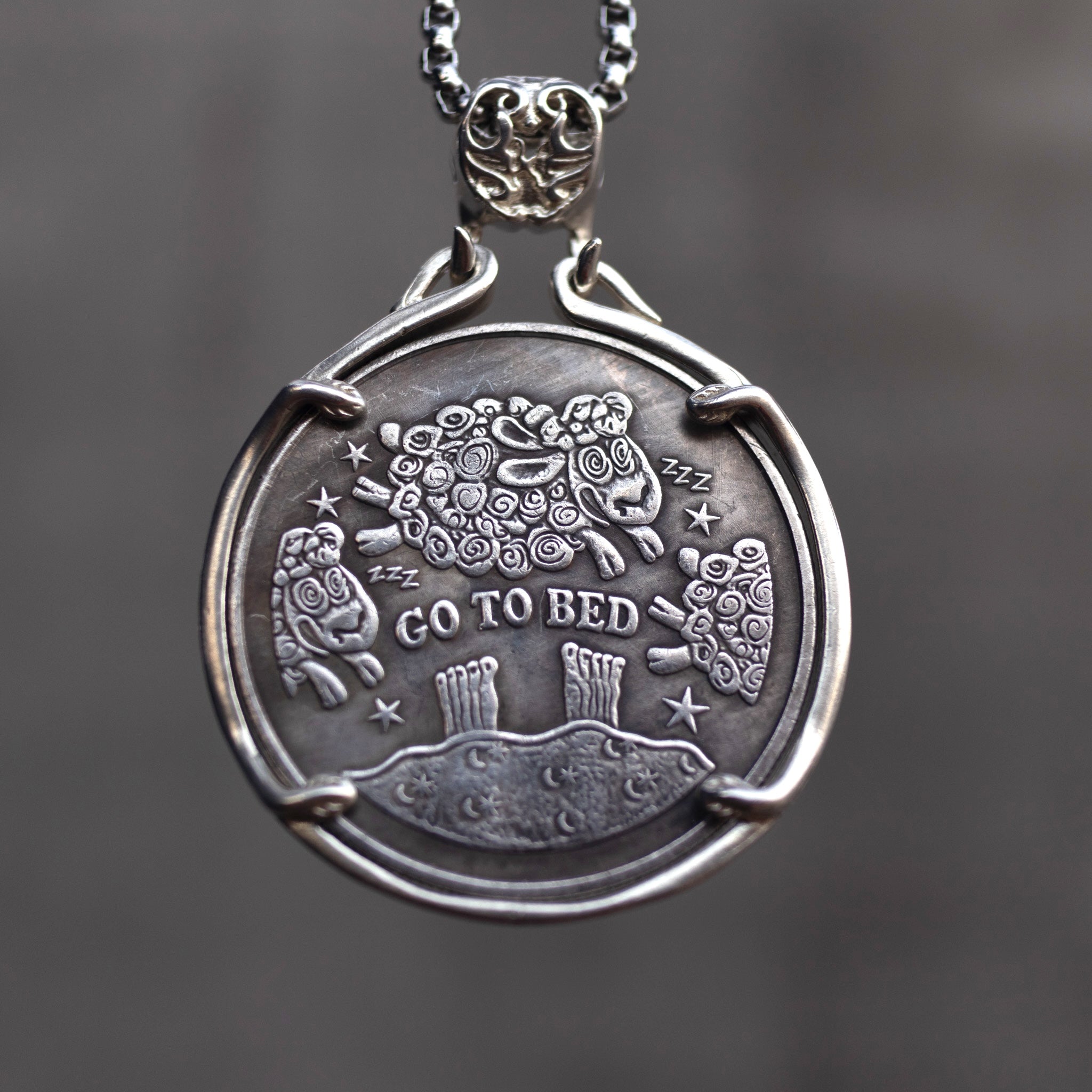 Double-sided book lover coin pendant showing the Go To Bed side with counting sheep jumping over a moonlit hill, set in a four-prong bezel on a box chain Main image