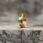 Gold-tone spinner ring with square emerald-green zircon stones shown upright