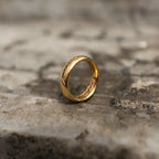 Highly polished gold-tone band ring with engraved script shown from the front