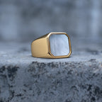 Gold-tone square signet ring with a white mother-of-pearl face, front view