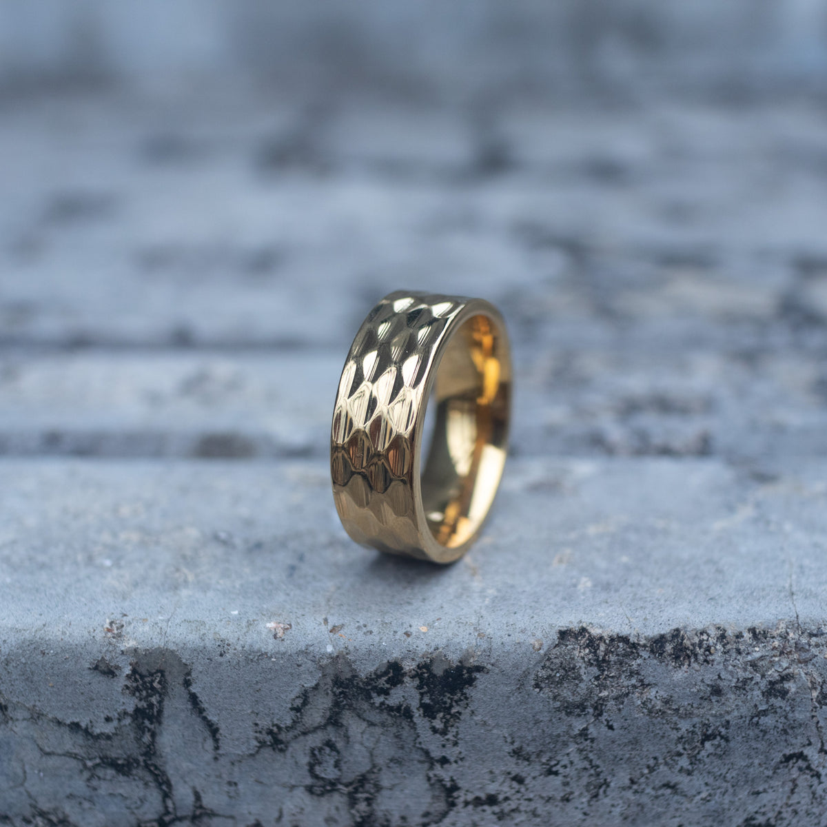 Gold-tone wide band ring with a polished repeating geometric pattern