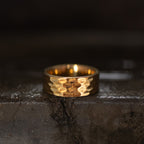 Gold-tone wide band ring with a repeating geometric faceted pattern