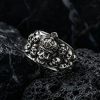 Detailed close-up of the gothic skull crown ring featuring a central crowned skull surrounded by cluster skulls on dark textured rock