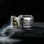 Gothic Voltaire skull ring with gold skull and engraved quote on dark rock with smoke