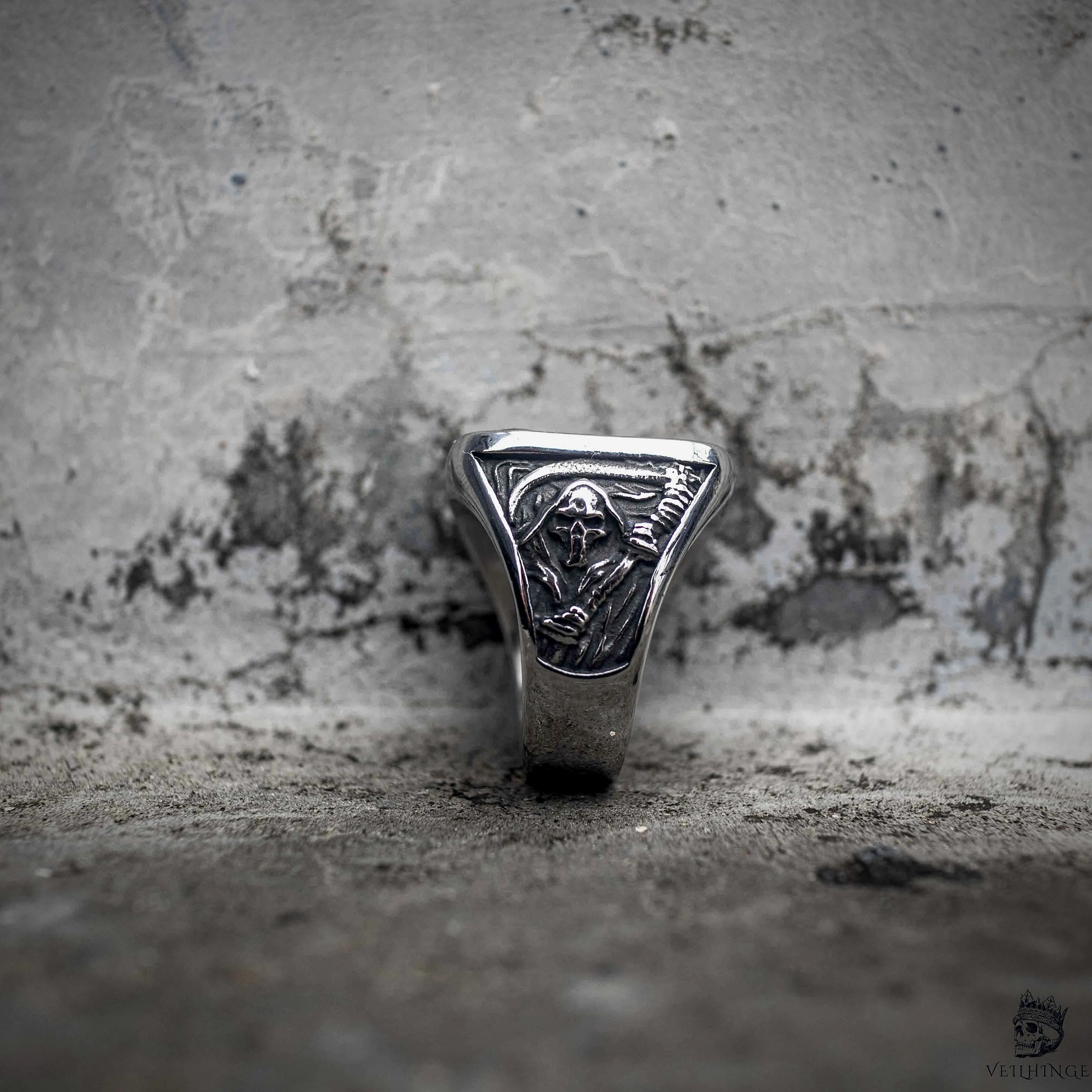 Gothic grim reaper ring with triangle face showing scythe and cross engraving, polished stainless steel, dark aesthetic memento mori ring by Veilhinge, front view