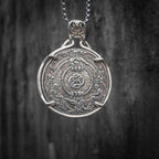 Coin pendant engraved with a coiled serpent at center framed by a rope ring, flanked by two kneeling figures holding the rope ends, E Pluribus Unum border, set in a four-prong bezel on a chain