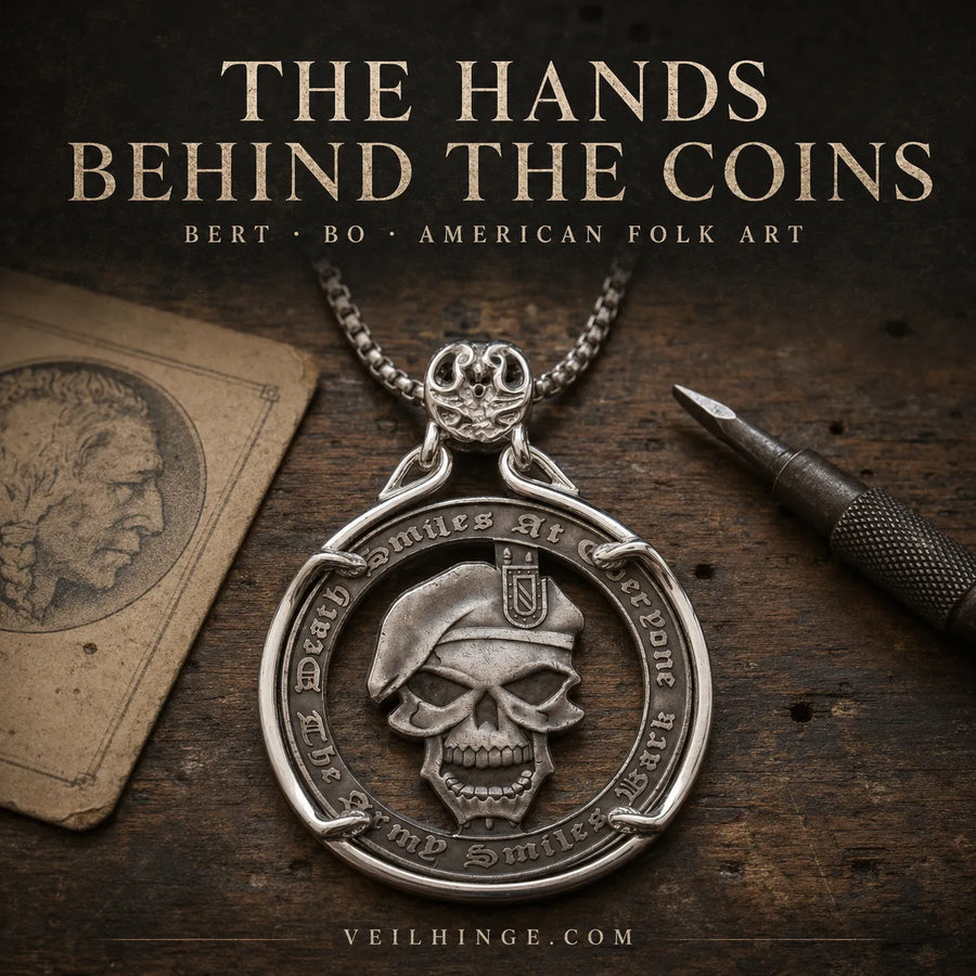 A silver pendant necklace with a skull wearing a beret and engraved text, displayed on a rustic dark wood surface with a chain, a carving tool, and a vintage card. Large text at the top reads 'THE HANDS BEHIND THE COINS' and 'BERT BO AMERICAN FOLK ART'; 'VEILHINGE.