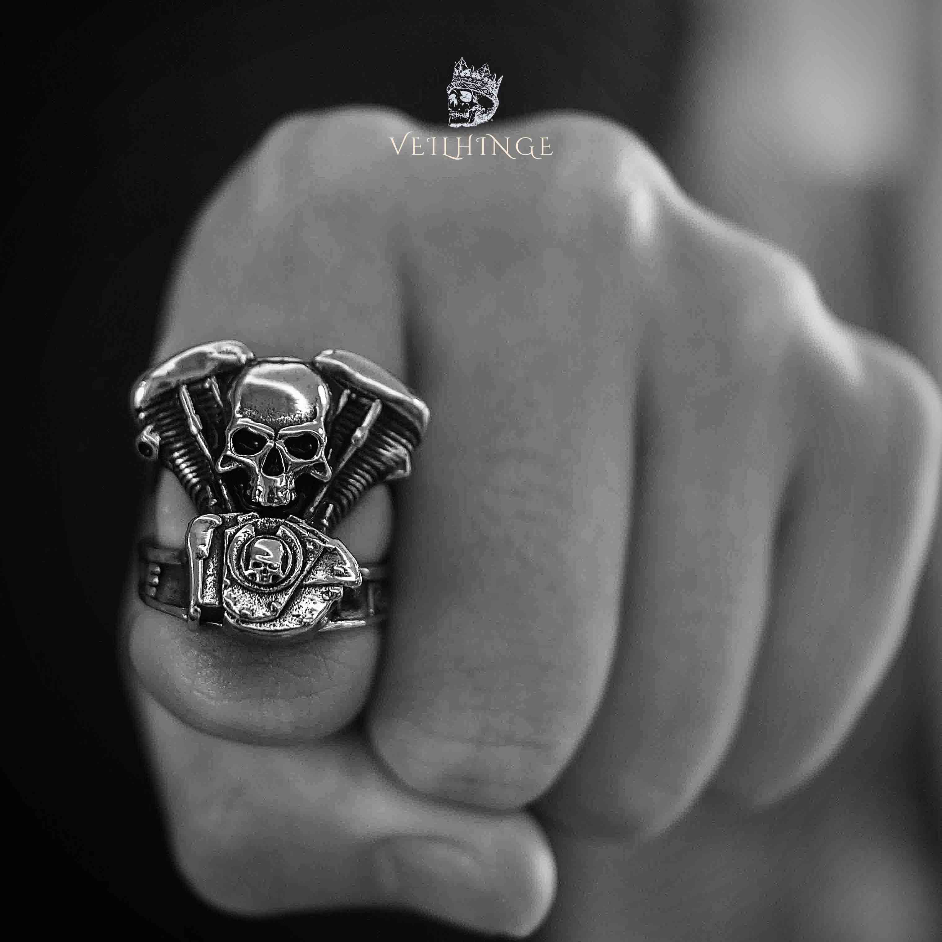 Live to Ride skull ring with V-twin engine body worn on a clenched fist, shot in black and white
