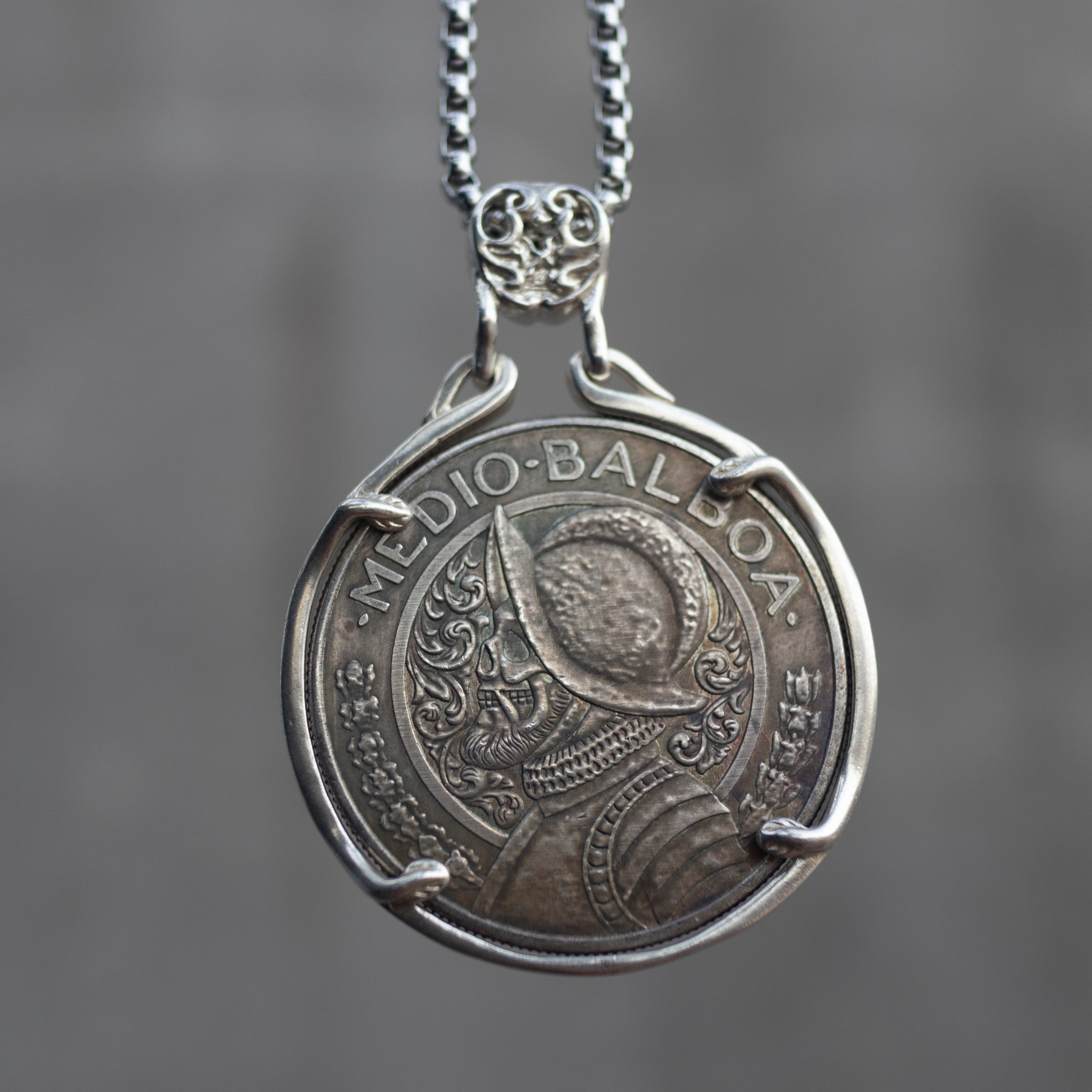 Coin pendant engraved with a Spanish conquistador in a morion helmet and armor, Medio Balboa inscription, set in a four-prong bezel on a decorative chain Main image