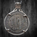 Coin pendant engraved with full-body Medusa with serpent tail coiled among ancient temple columns, dated 1902, set in a four-prong bezel on a chain