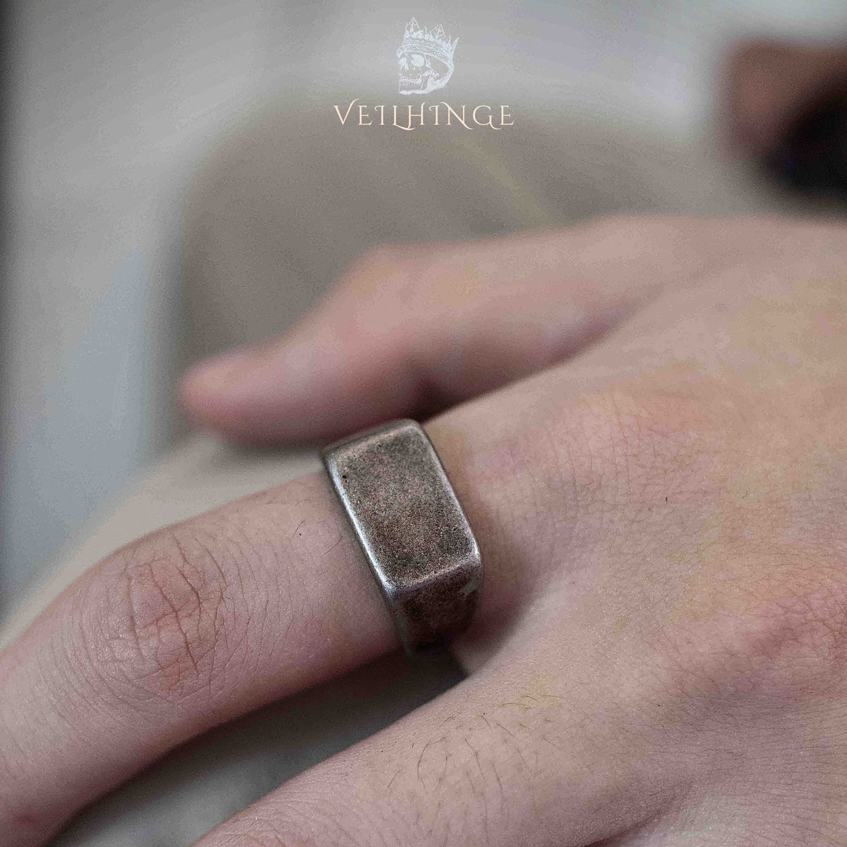 Minimalist square signet ring in brushed oxidized silver worn on a hand, flat smooth face with clean beveled edges and a wide band