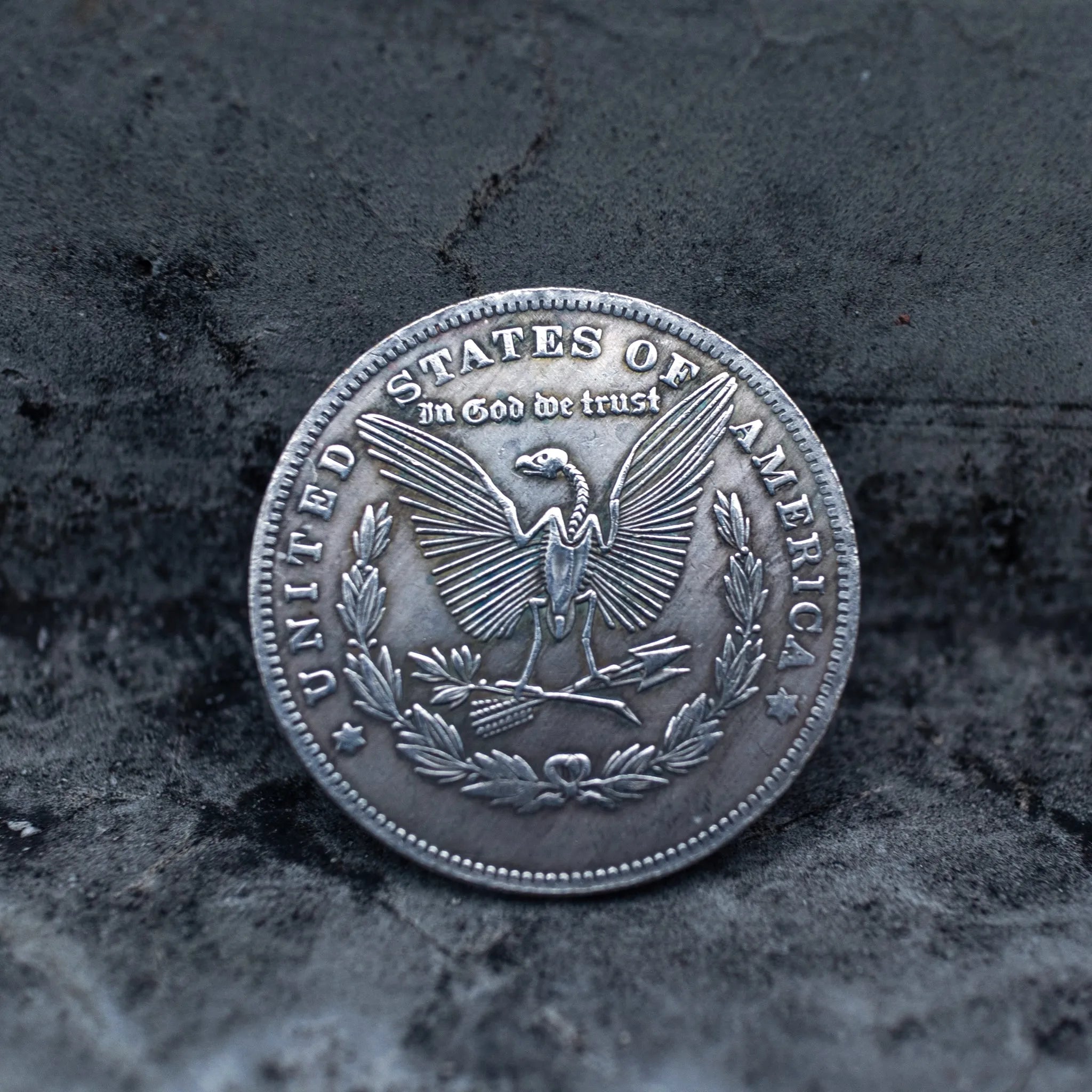 Morgan Dollar reverse showing the American eagle, In God We Trust and United States of America inscriptions, One Dollar denomination on dark stone