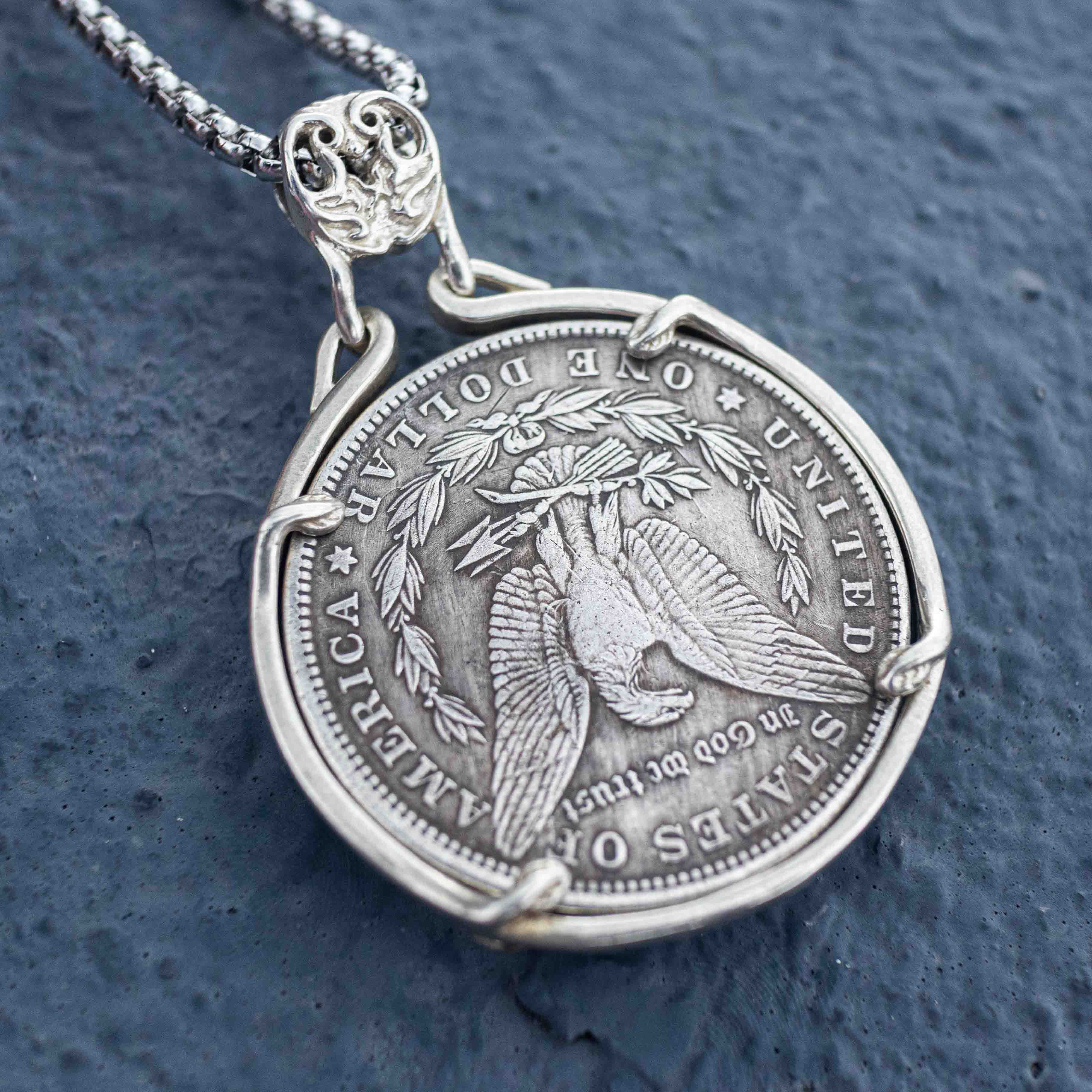Bull skull coin pendant reversed to show the Morgan Dollar eagle with United States of America and One Dollar inscription, in a four-prong open bezel