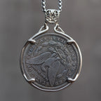 Evil Queen witch coin pendant reversed to show the Morgan Dollar eagle face, suspended from a skull bail on a box chain