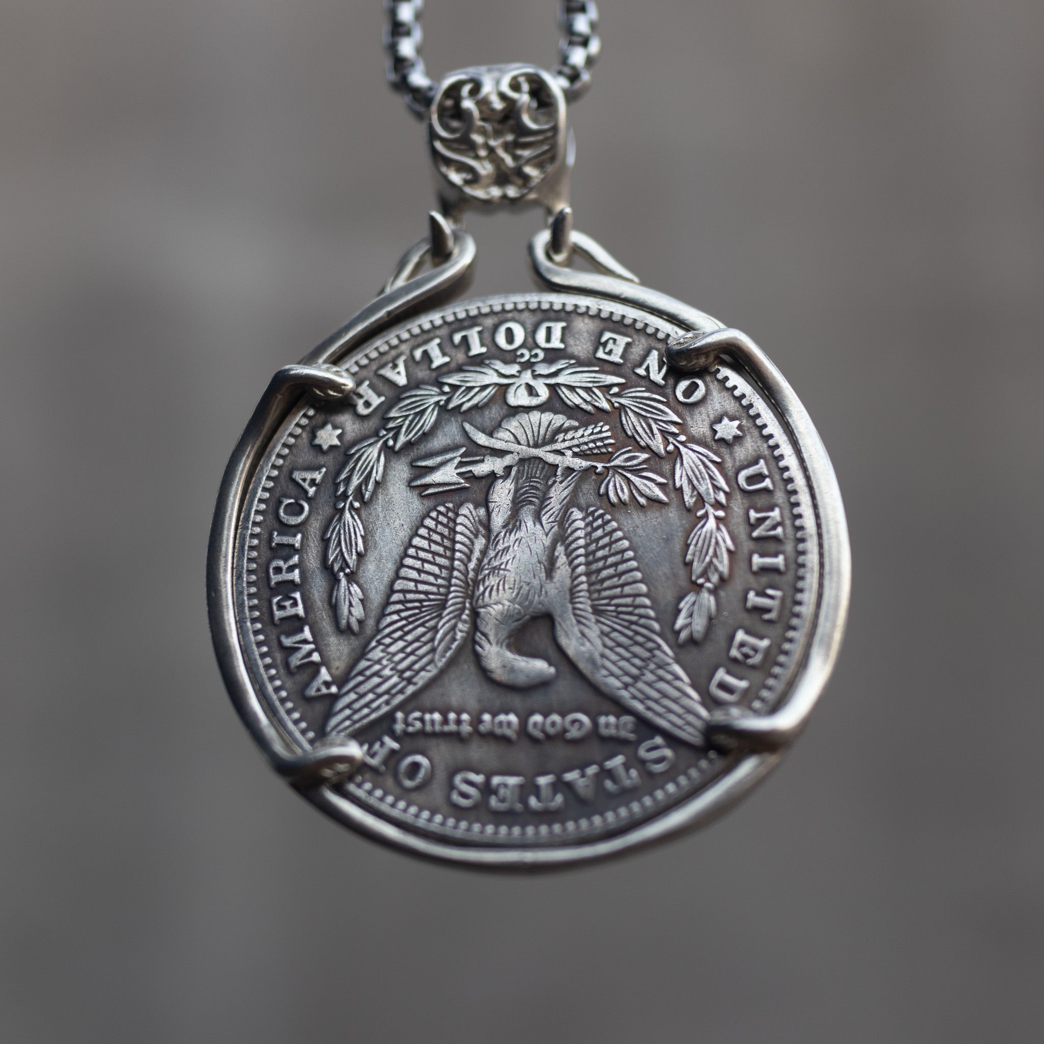 Eye of Providence coin pendant reversed to show the Morgan Dollar eagle with One Dollar inscription, held in a four-prong open bezel