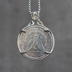 Four skulls anchor Carpe Diem coin pendant reversed to show the Morgan Dollar eagle with United States of America and One Dollar inscription, in a four-prong open bezel