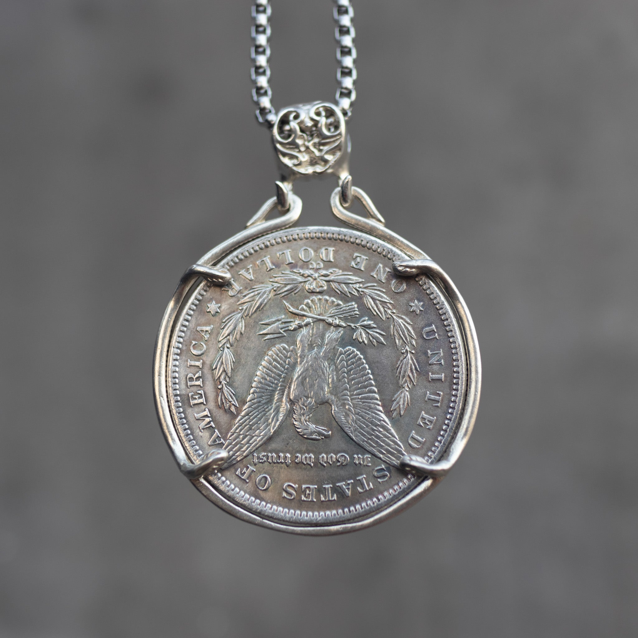 Four skulls anchor Carpe Diem coin pendant reversed to show the Morgan Dollar eagle with United States of America and One Dollar inscription, in a four-prong open bezel