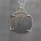 Pirate captain skull coin pendant reversed to show the Morgan Dollar eagle with United States of America inscription, held in a four-prong open bezel