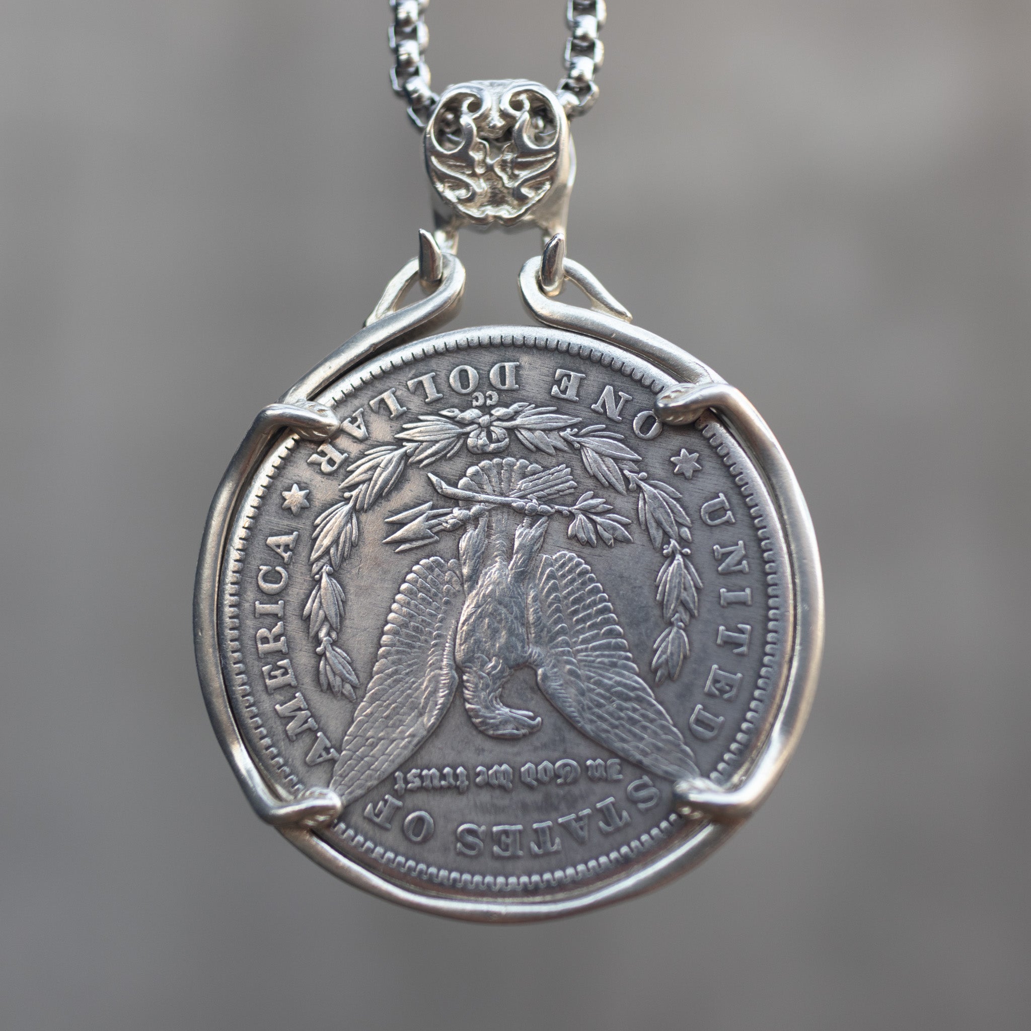 Skeleton pirate captain coin pendant reversed to show the Morgan Dollar eagle with One Dollar inscription, held in a four-prong open bezel on a box chain