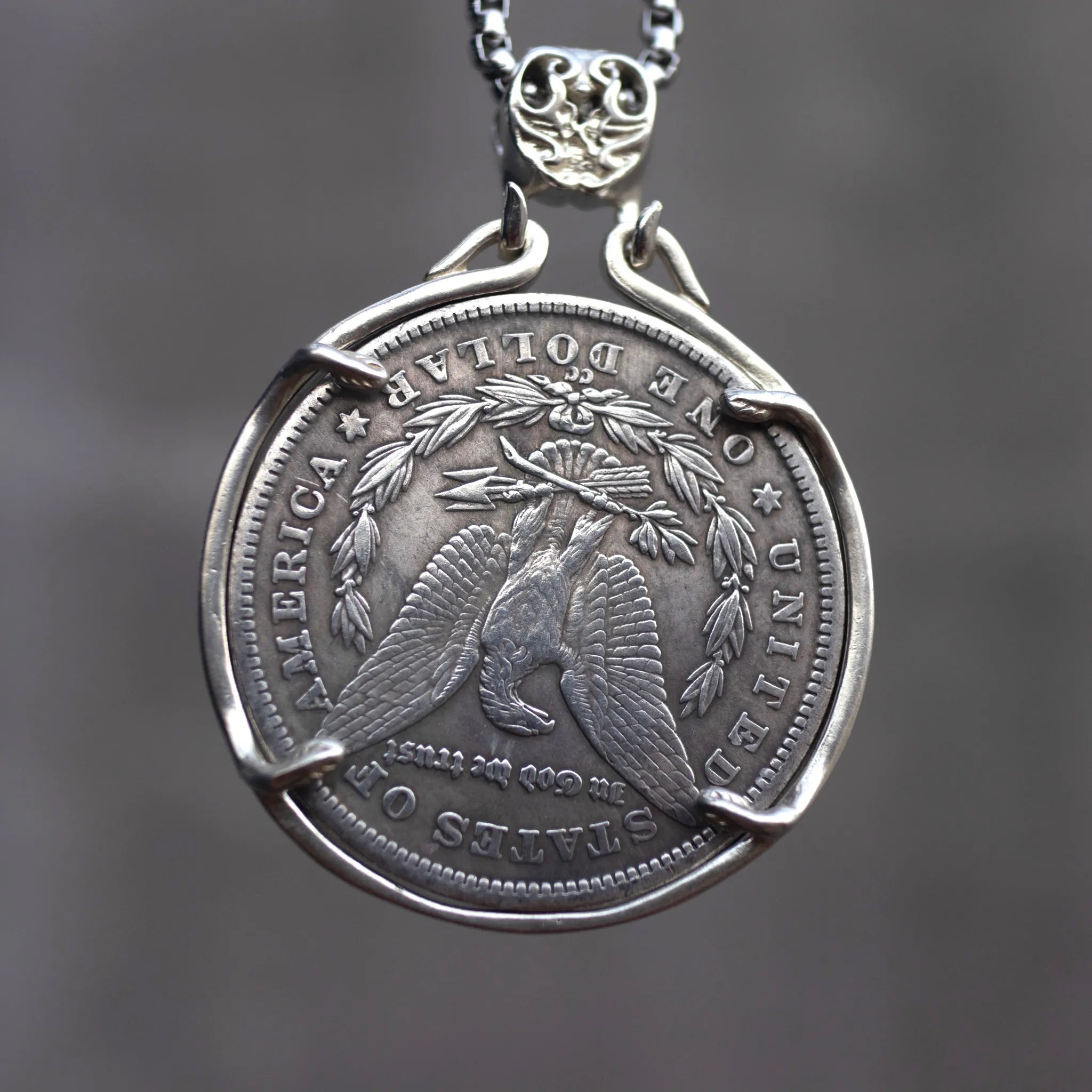 Skull chief coin pendant reversed to show the Morgan Dollar eagle with United States of America and One Dollar inscription, in a four-prong open bezel on a chain